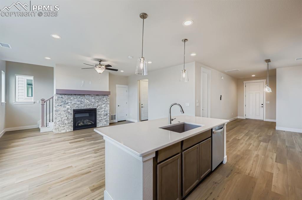 Image 9 of 28: Kitchen featuring open floor plan, pendant lighting, light wood-style floor