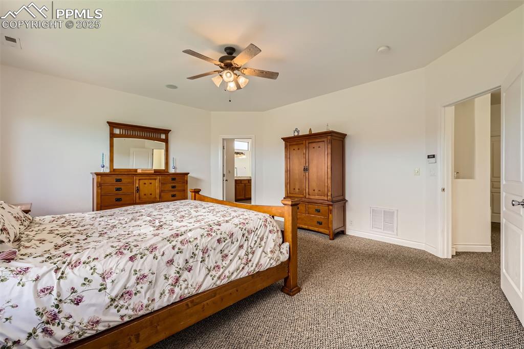 Image 14 of 28: Master bedroom with carpet flooring and a ceiling fan
