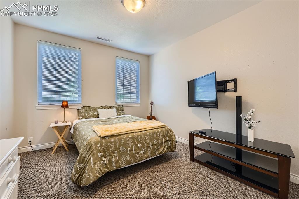Image 18 of 28: Bedroom with carpet floors and baseboards