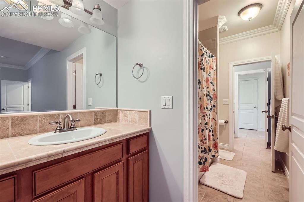 Image 23 of 28: Full bathroom featuring vanity, ornamental molding, tile patterned flooring