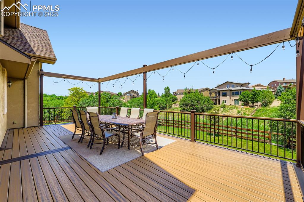 Image 26 of 28: Custom composite deck featuring outdoor dining area and an open space/green