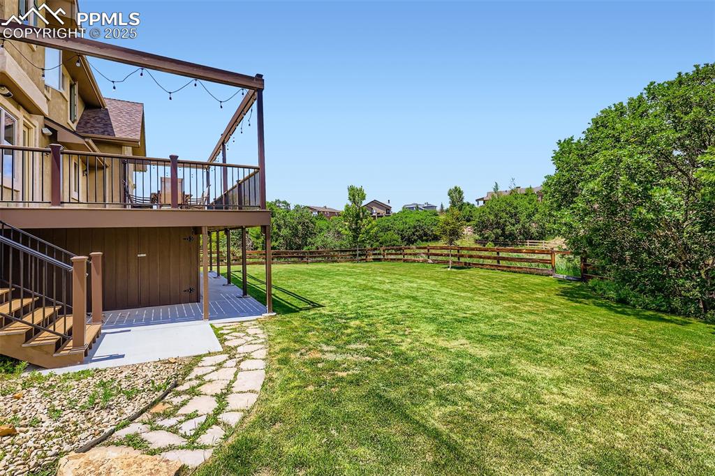 Image 27 of 28: Fenced backyard featuring stairs and a custom composite deck