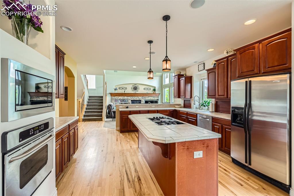 Image 8 of 28: Kitchen featuring appliances with stainless steel finishes, tile countertop