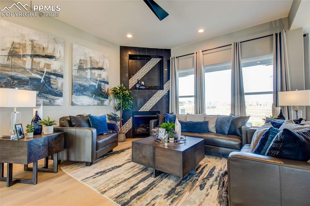 Image 11 of 30: Living room with wood finished floors and recessed lighting