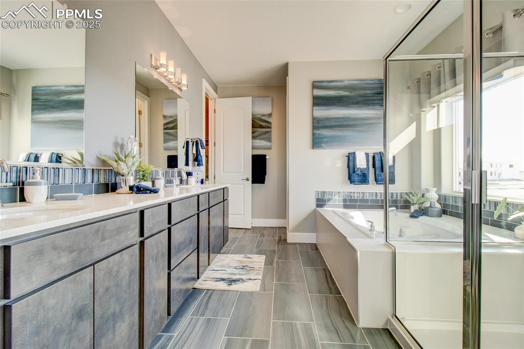 Image 16 of 30: Full bathroom featuring double vanity, a bath, and a shower stall