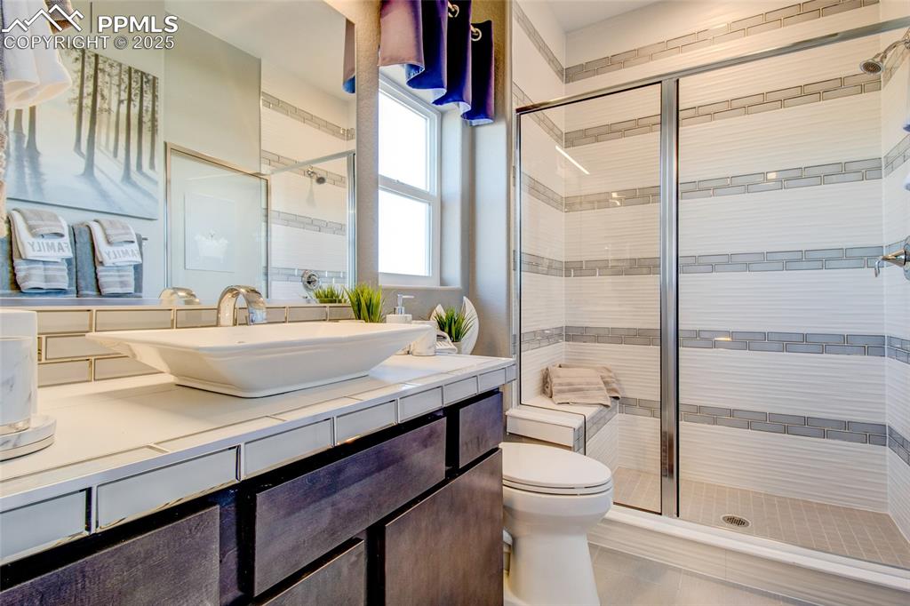 Image 19 of 30: Bathroom featuring a shower stall, vanity, and tile patterned flooring