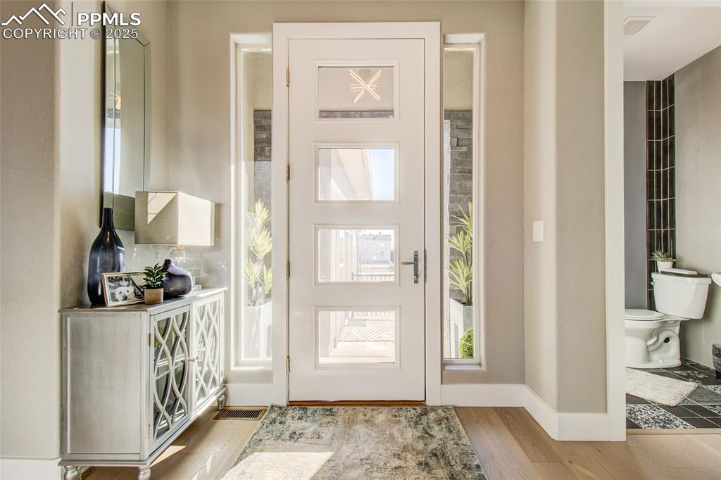 Image 4 of 30: Foyer featuring wood finished floors and baseboards