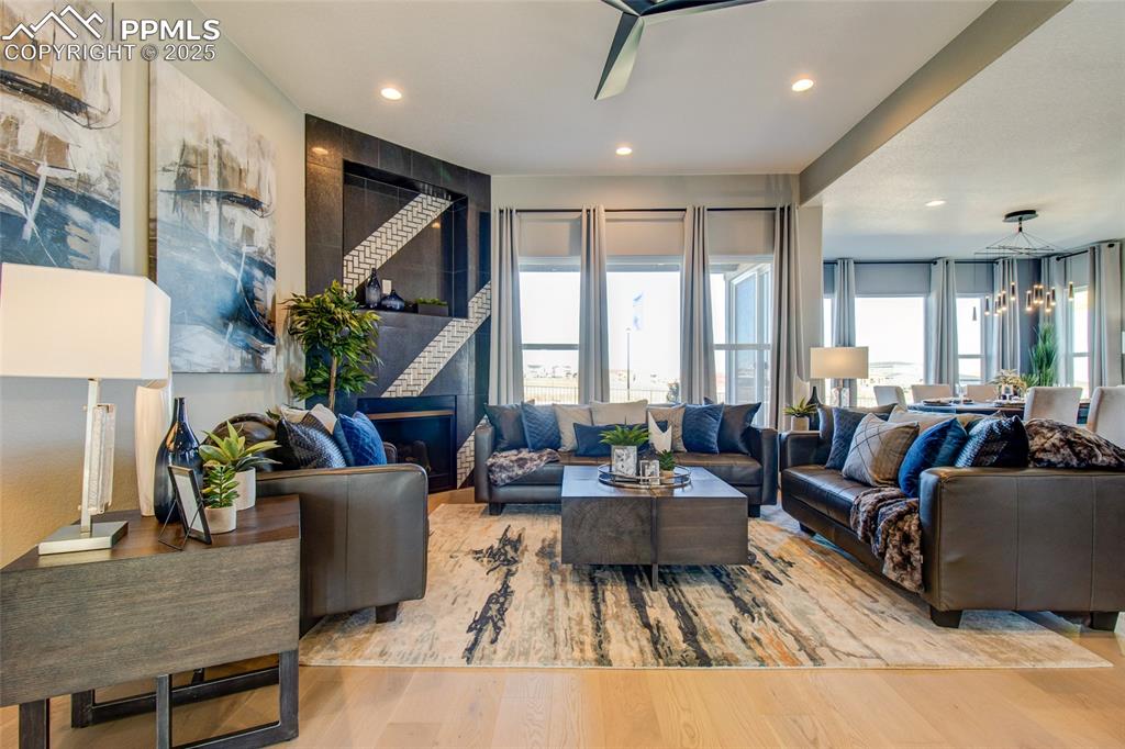 Image 5 of 30: Living room featuring wood finished floors, a chandelier, recessed lighting