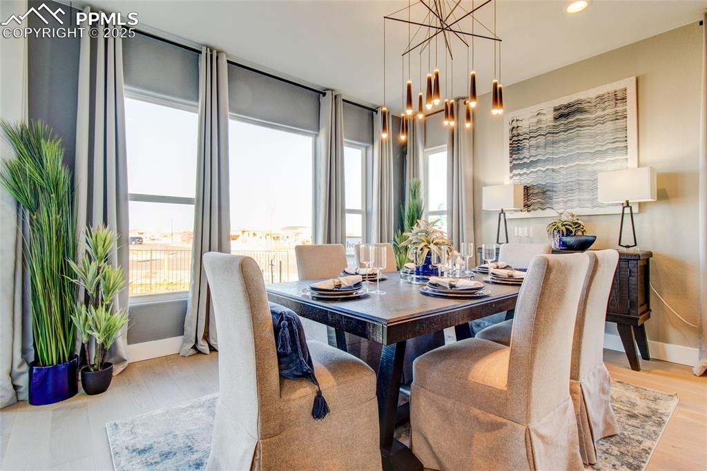 Image 8 of 30: Dining room with wood finished floors, a chandelier, and recessed lighting