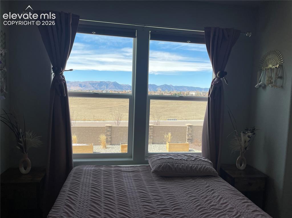 Image 10 of 25: Bedroom with a mountain view and multiple windows