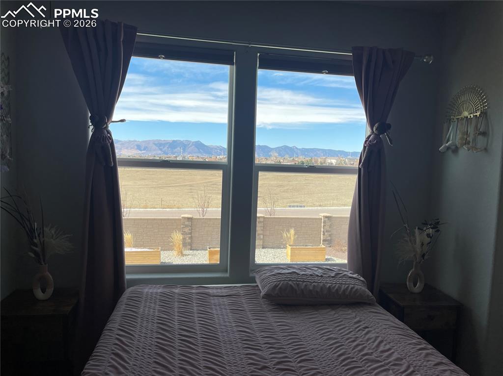 Image 11 of 26: Bedroom with a mountain view and multiple windows