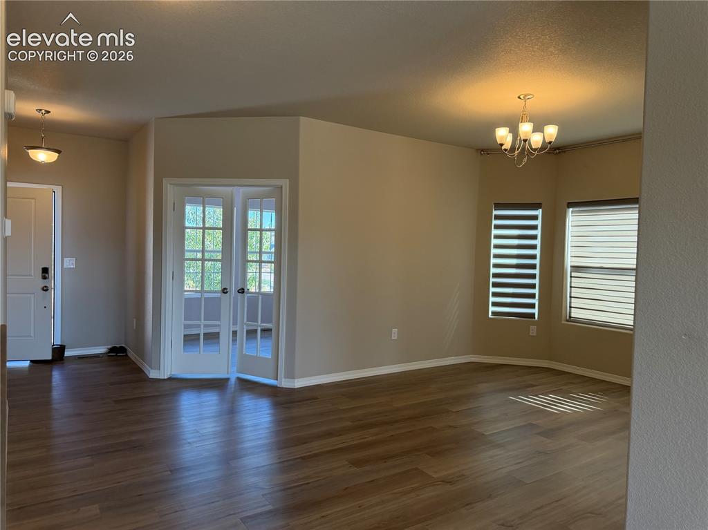 Image 13 of 24: Wood-finish flooring throughout, complemented by a contemporary chandelier
