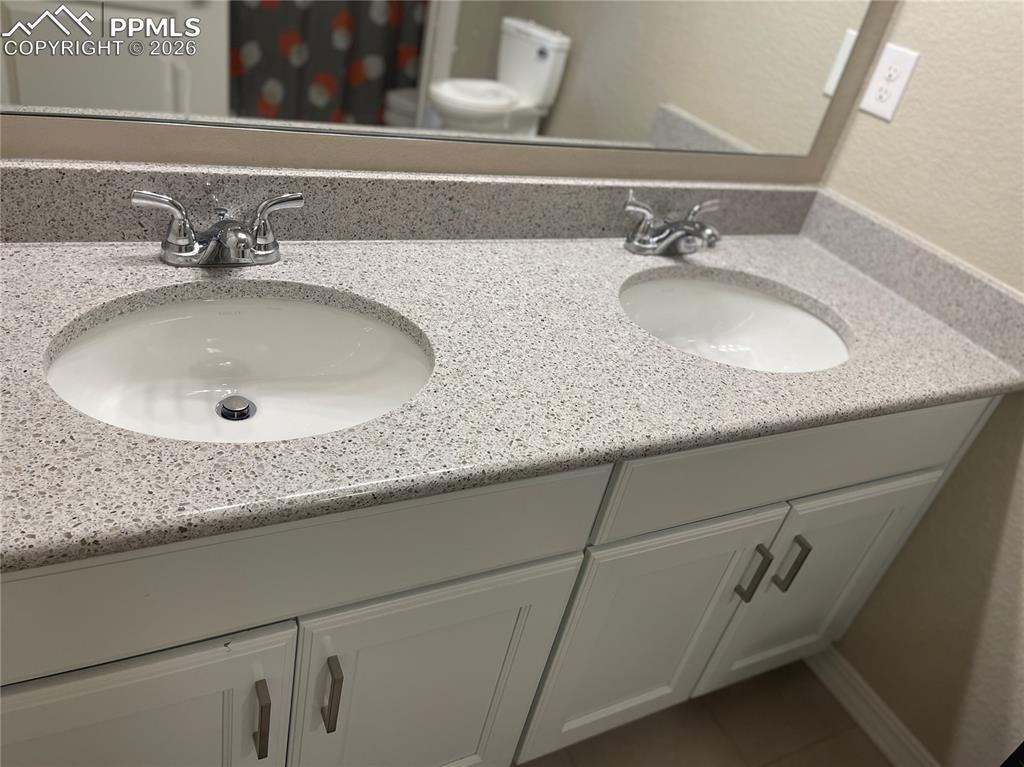 Image 14 of 26: Full bathroom with double vanity and tile patterned flooring