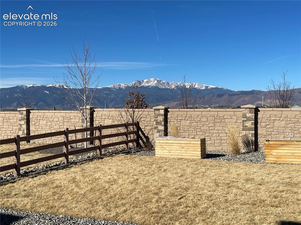 Image 22 of 25: Fenced backyard featuring a mountain view