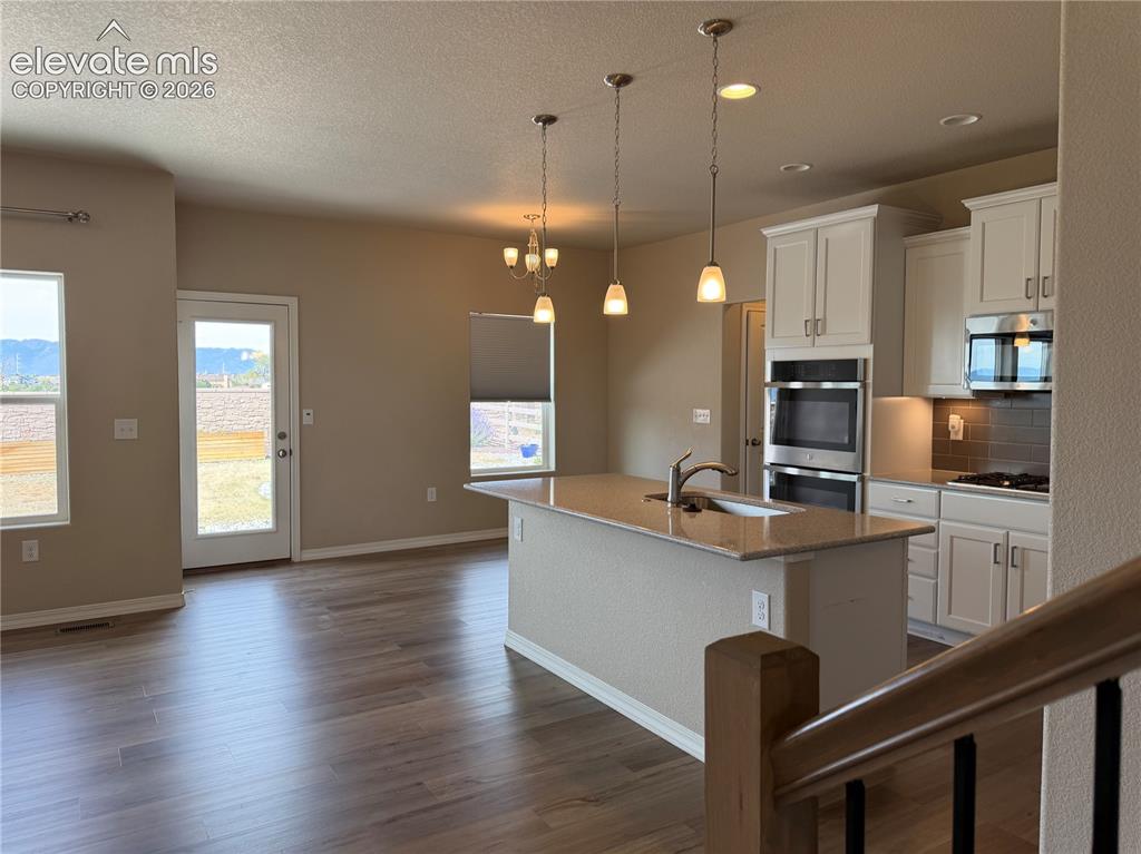 Image 5 of 24: Open-concept kitchen with a central island, recessed lighting, and stainles