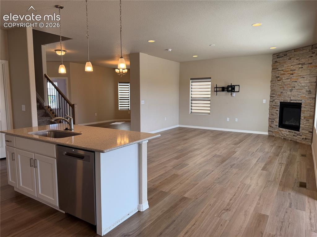 Image 6 of 24: Open-concept living area featuring wood-finish flooring, a kitchen island w