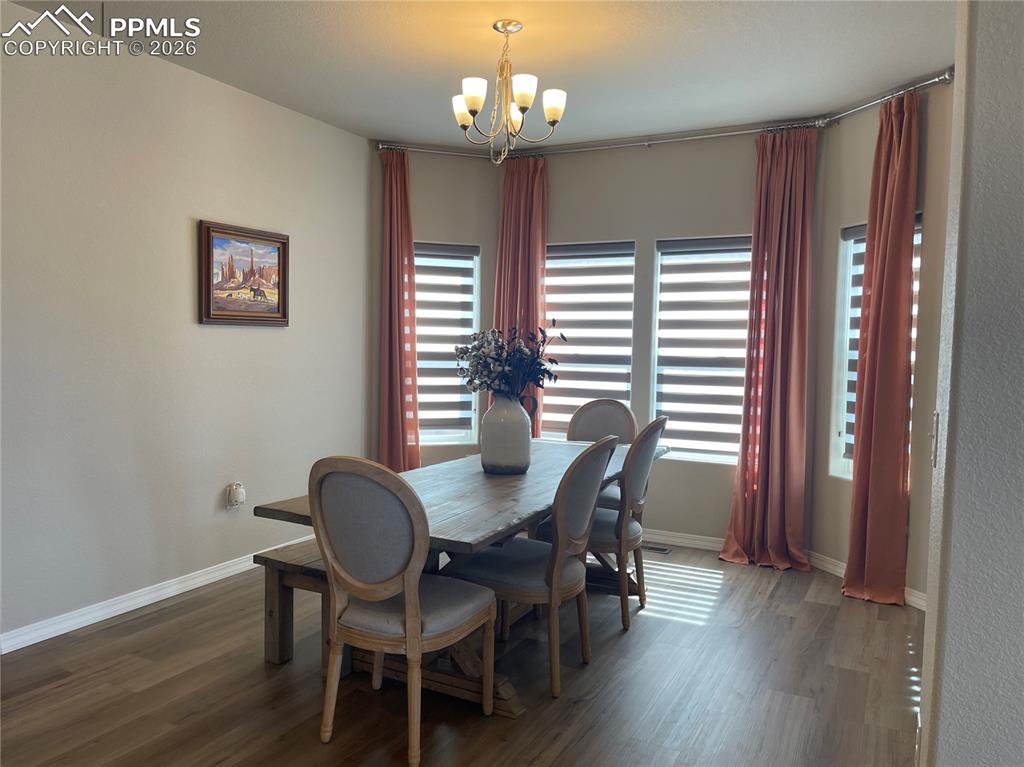 Image 8 of 26: Dining room featuring suspended lighting and wood finished floors