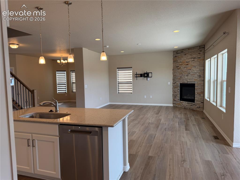 Image 8 of 24: Kitchen island with integrated sink, stainless steel dishwasher, and stone-