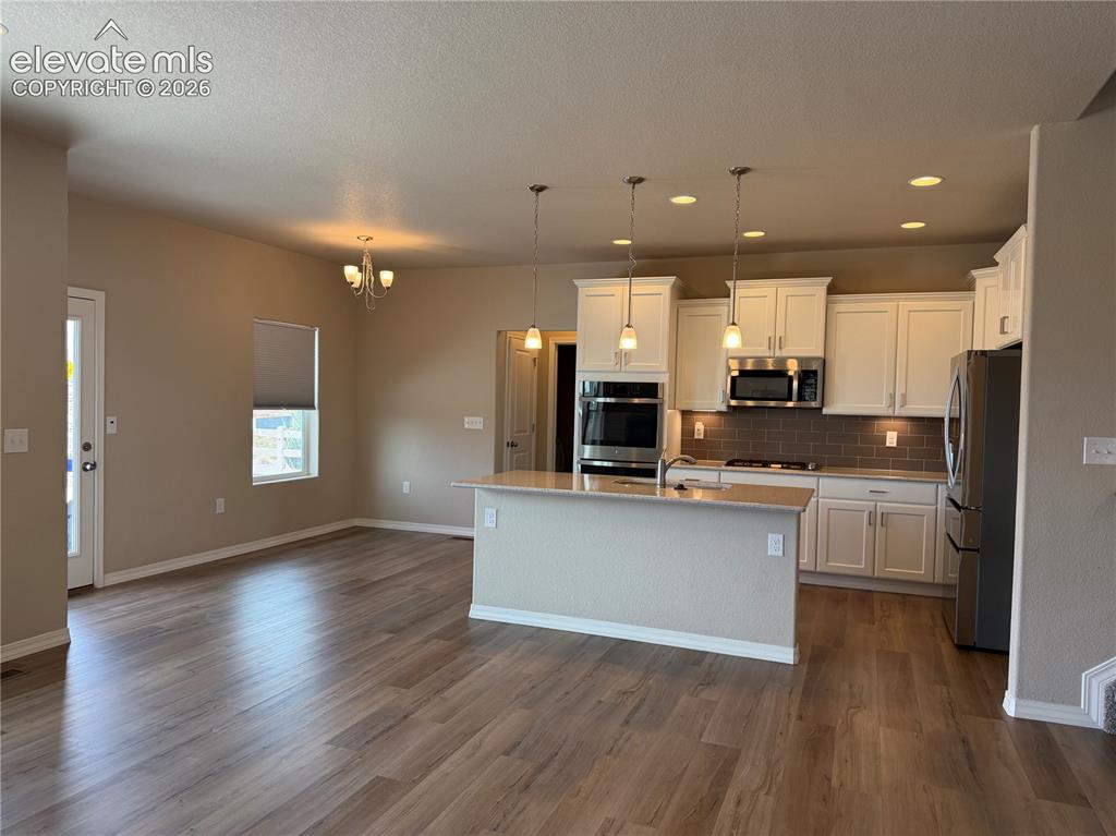 Image 9 of 24: Open-concept living space featuring wood-finish flooring, a kitchen island