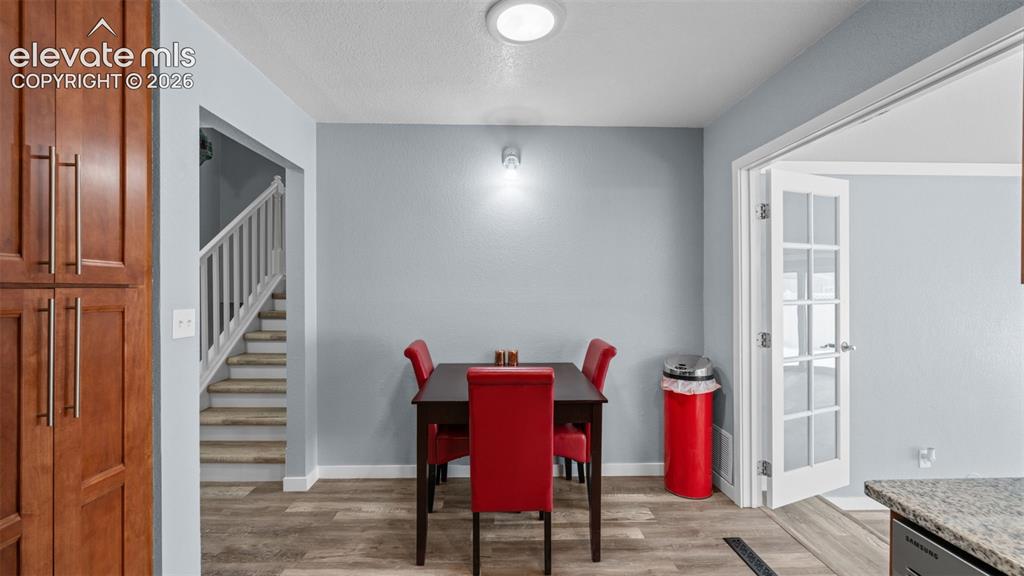 Image 14 of 39: Spacious dining area featuring wood-finish flooring, light blue wall finish