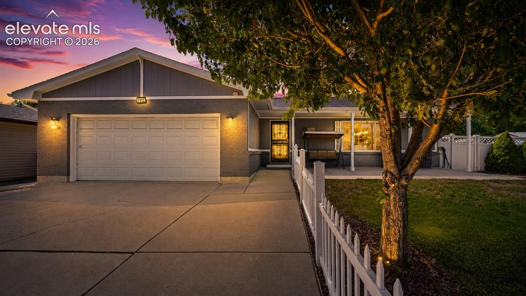 Image 2 of 39: Stucco exterior with a gable roofline, featuring an attached garage with a