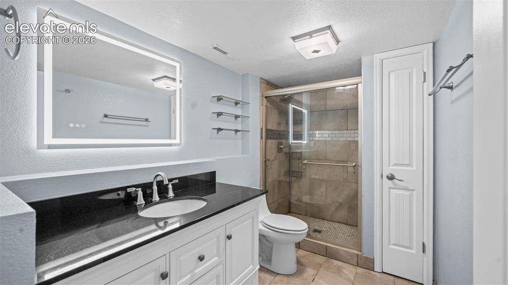 Image 20 of 39: Spacious room featuring a prominent fireplace with a mosaic tile surround a