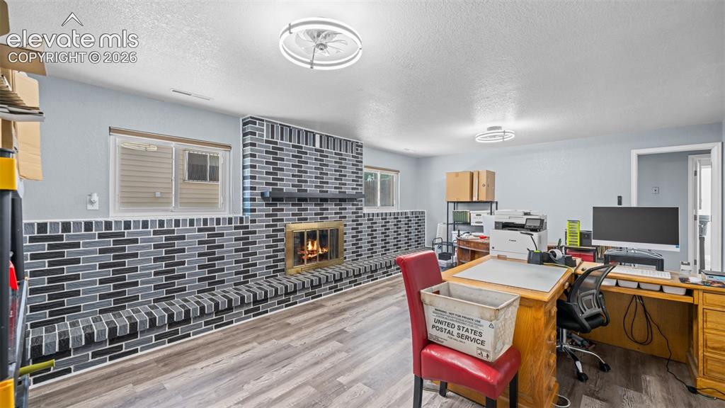 Image 23 of 39: Spacious room featuring wood-finish flooring, light blue walls, and a conte
