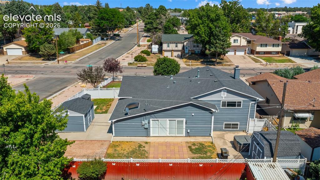 Image 34 of 39: Residential street featuring single-family homes, mature trees, mountain ba