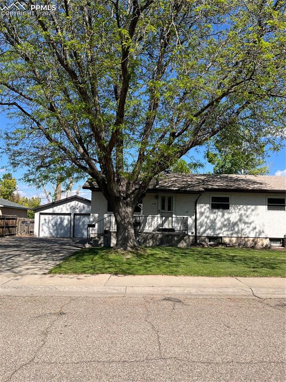 Caption: View of front of home featuring an outbuilding, a detached garage, a front lawn, and concrete drivew
