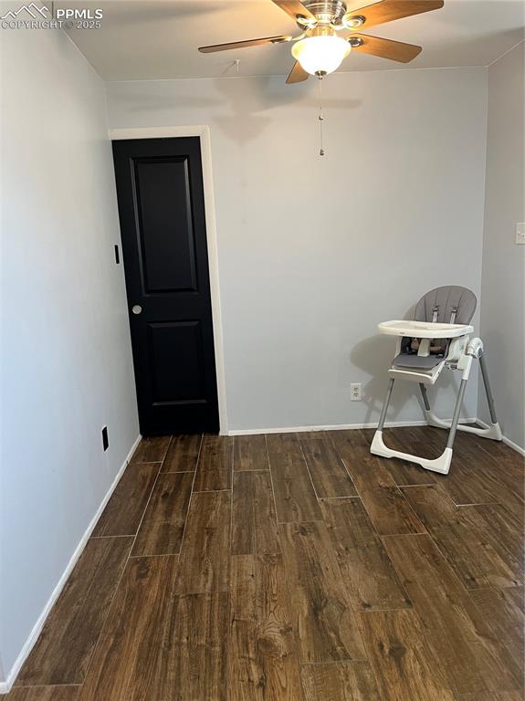 Image 10 of 29: Unfurnished room with wood finished floors, a ceiling fan, and baseboards