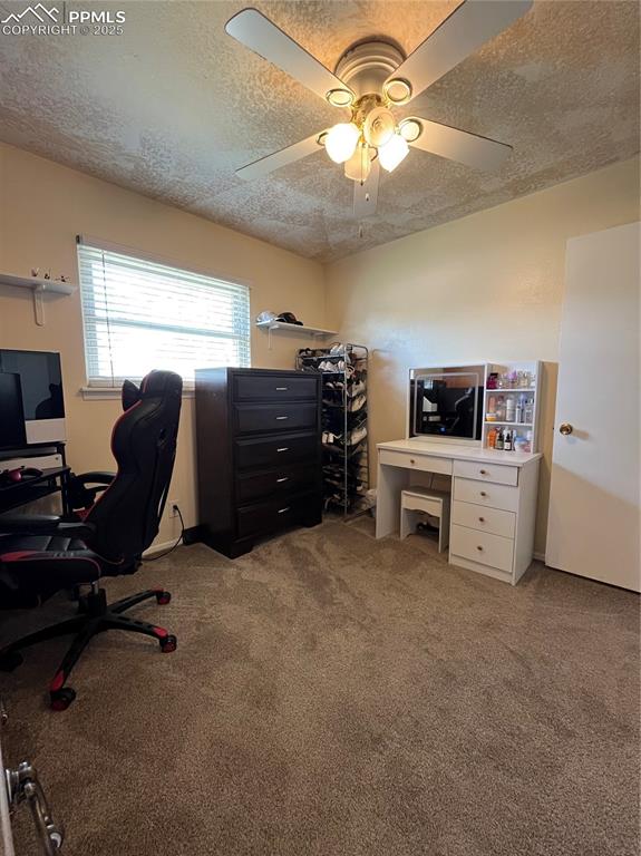 Image 15 of 29: Office space with a textured ceiling, light colored carpet, and ceiling fan