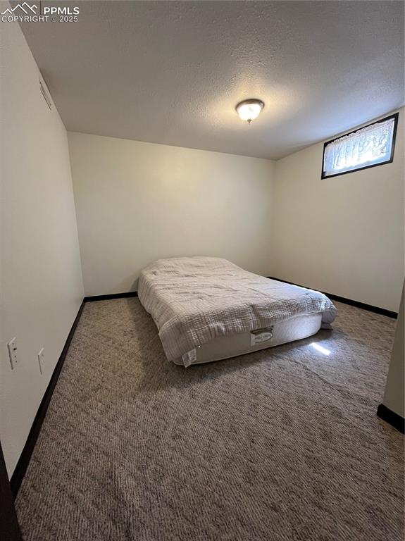 Image 21 of 29: Carpeted bedroom featuring baseboards and a textured ceiling