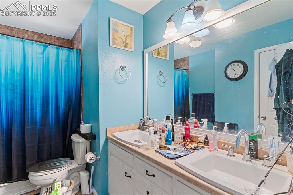 Image 19 of 25: Full bath featuring double vanity and a shower with shower curtain