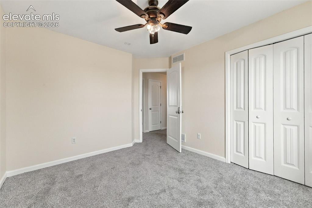 Image 11 of 50: Neutral-toned wall paint, wall-to-wall carpeting, ceiling fan with integrat