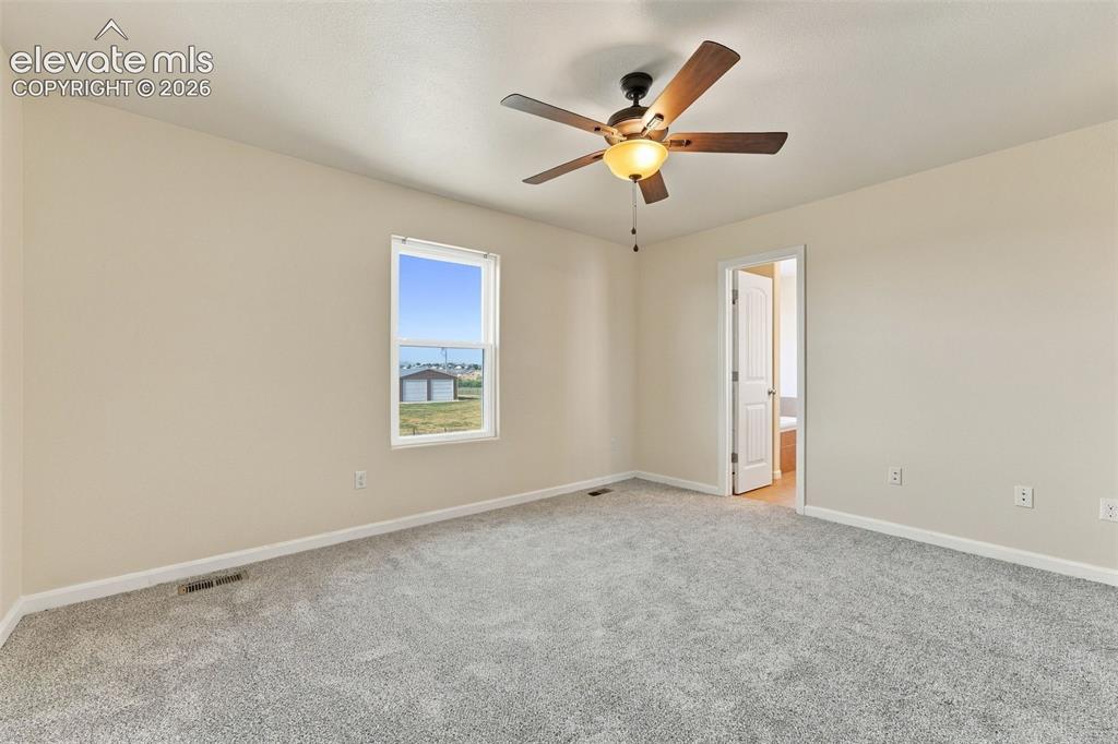 Image 12 of 50: Neutral-toned interior room featuring wall-to-wall carpeting, a single-pane