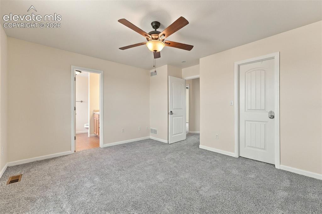 Image 13 of 50: Neutral-toned interior space featuring gray wall-to-wall carpeting, a centr