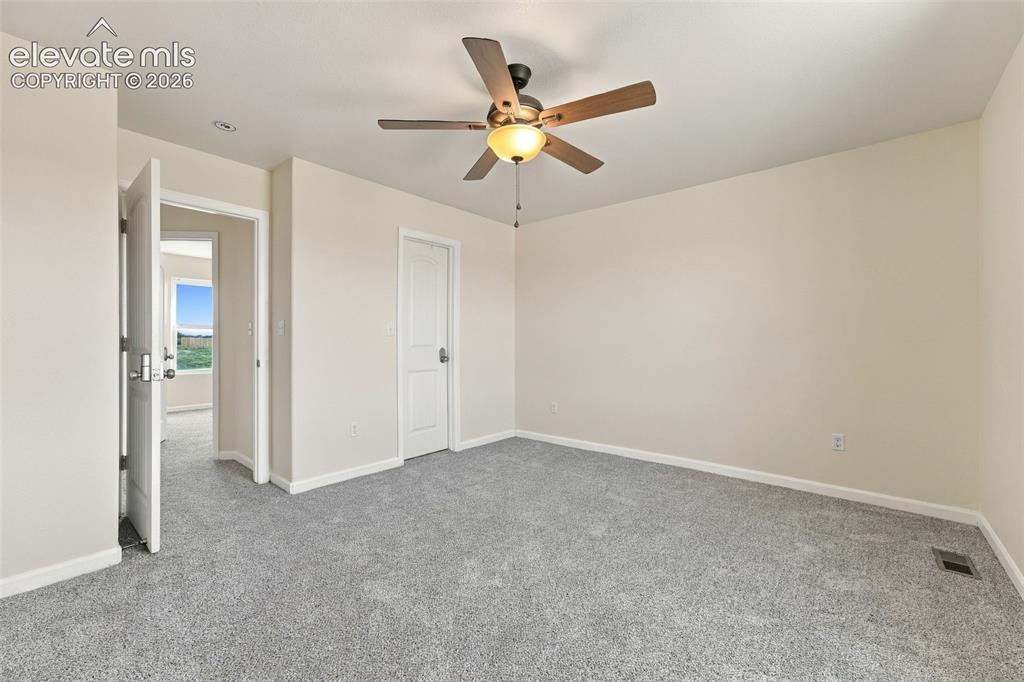 Image 14 of 50: Neutral-toned room featuring neutral wall-to-wall carpeting, a multi-blade 