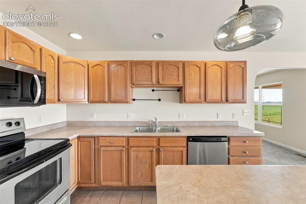 Image 19 of 50: Kitchen featuring light-finish cabinetry, neutral solid-surface countertops