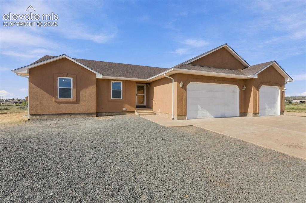 Image 2 of 50: Stucco exterior featuring a multi-gable roofline, three-car garage, concret