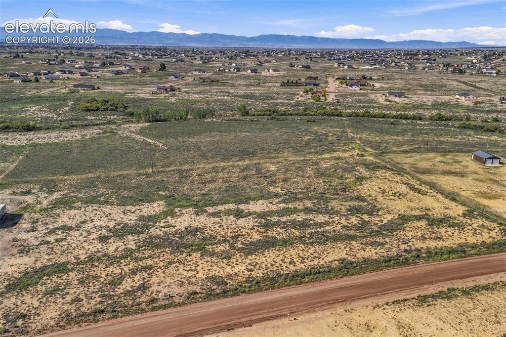 Image 40 of 50: Expansive parcel of land featuring native vegetation, a detached storage st