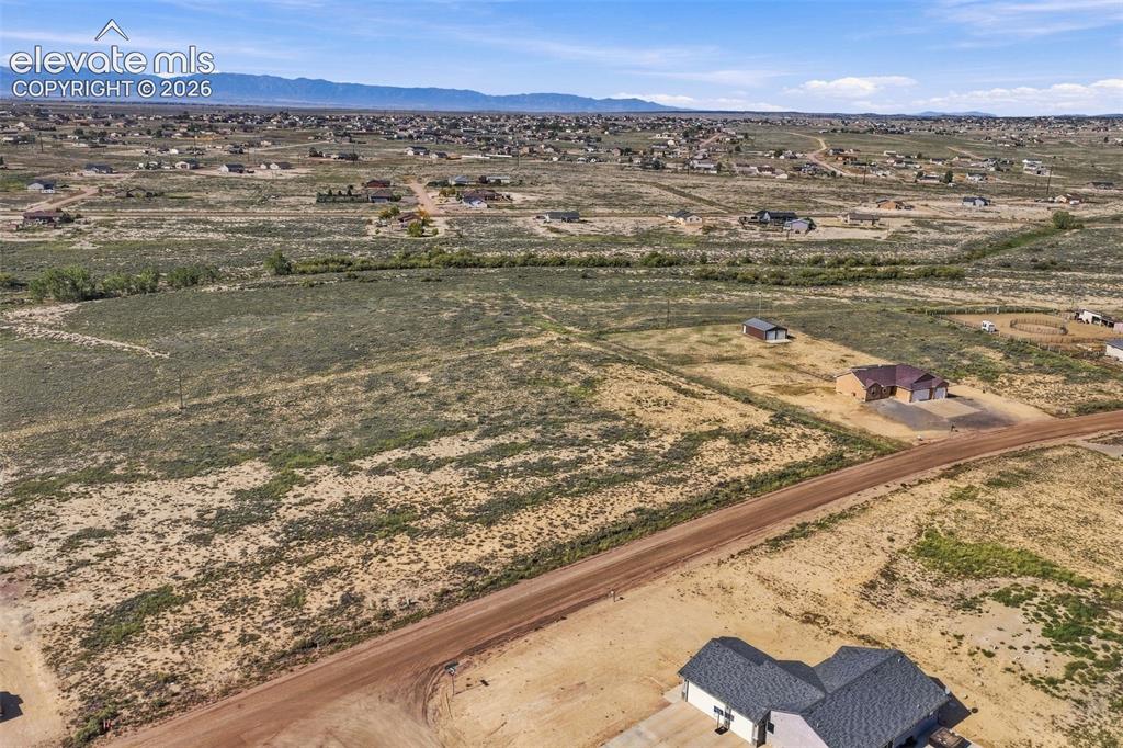 Image 41 of 50: Expansive acreage featuring native high-desert terrain, a wide dirt road fr