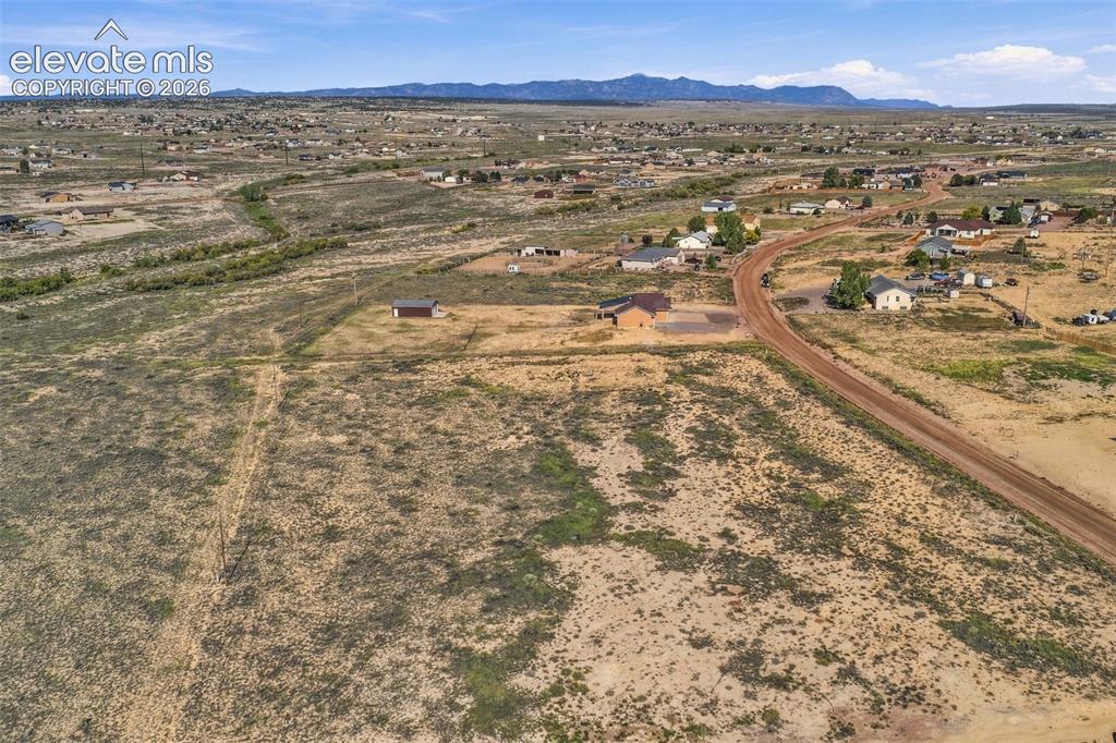 Image 42 of 50: Expansive acreage featuring native landscape, a dirt road frontage, and a m