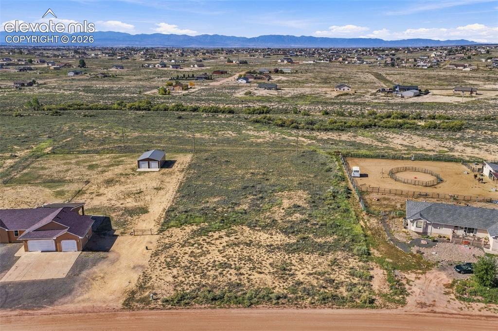 Image 49 of 50: Expansive land parcel featuring a detached metal-roofed structure, mountain