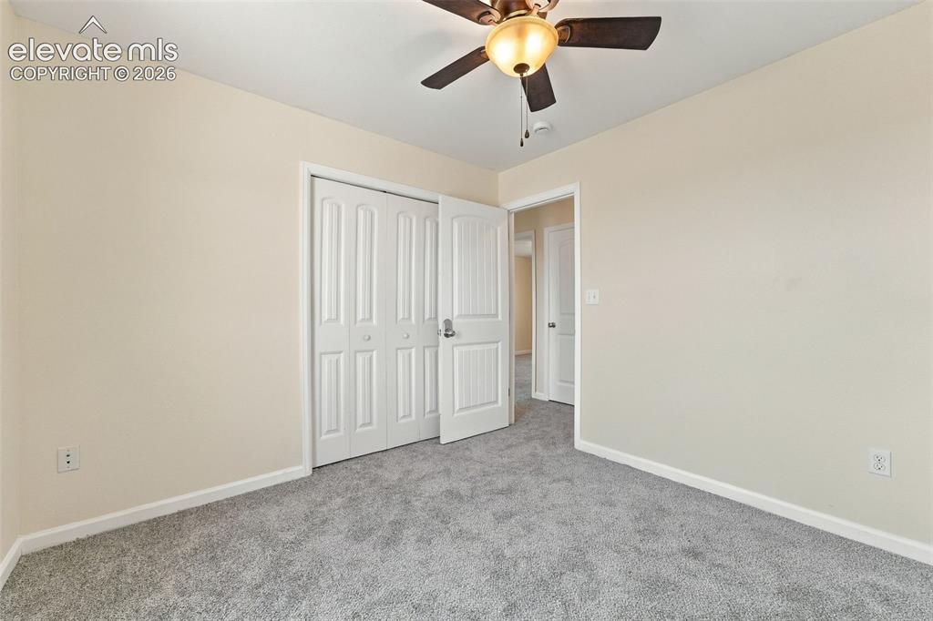 Image 8 of 50: Neutral wall finishes, carpeted flooring, built-in closet with paneled door