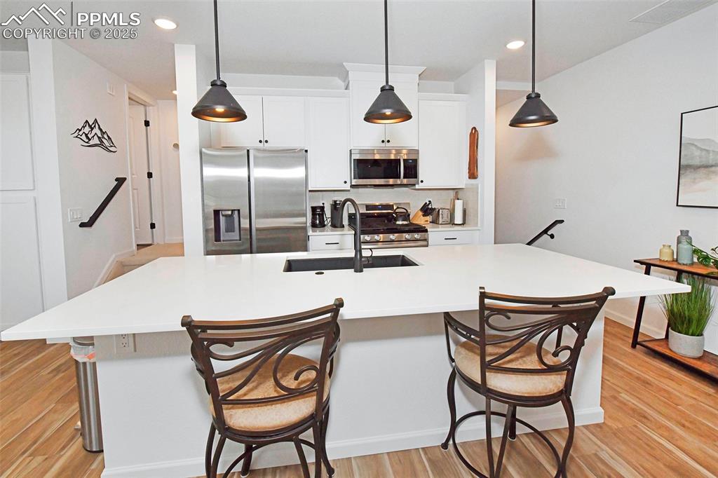 Image 10 of 26: Kitchen featuring stainless steel appliances, decorative light fixtures, a