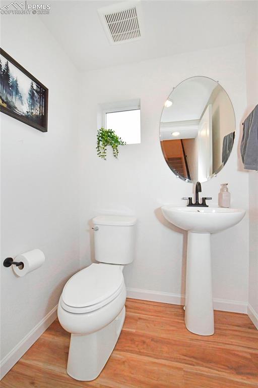 Image 16 of 26: Half bathroom with light wood-style flooring