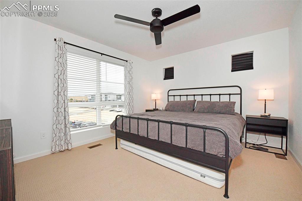 Image 17 of 26: Bedroom with light carpet and ceiling fan