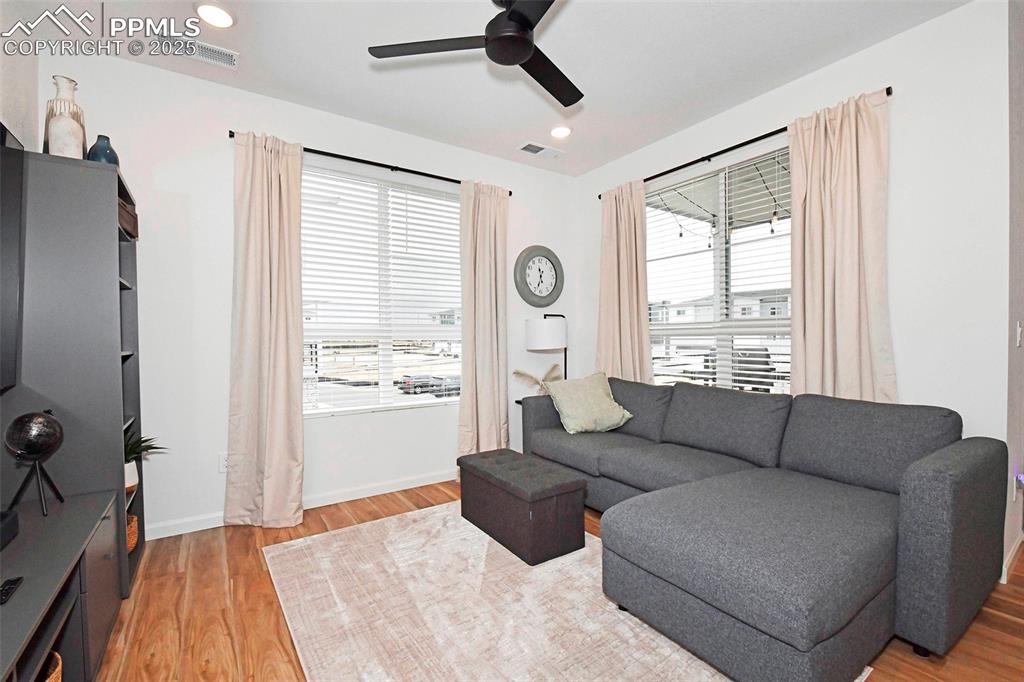Image 8 of 26: Living area with light wood-style flooring, ceiling fan, and recessed light