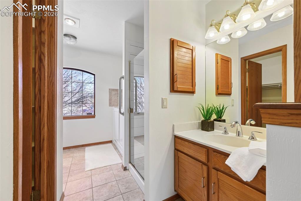 Image 12 of 42: En-suite bathroom with vanity, shower, walk-in jetted tub, toilet and walk-