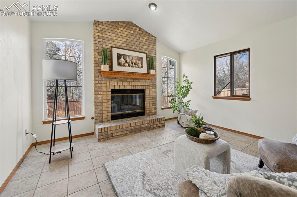 Image 19 of 42: Bright family room with brick gas fireplace